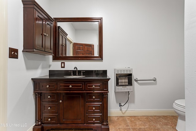 bathroom featuring vanity, heating unit, and toilet