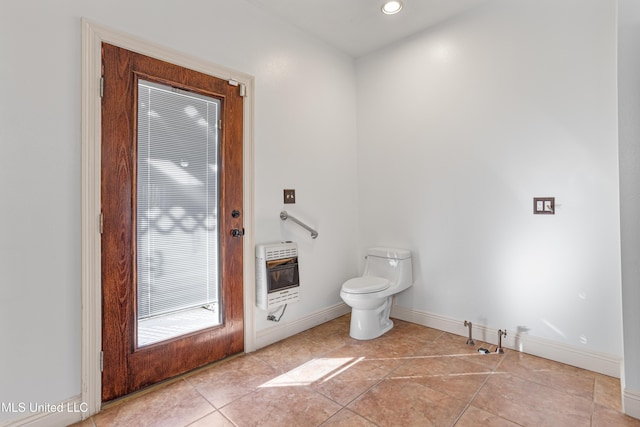 bathroom with tile patterned flooring, heating unit, and toilet