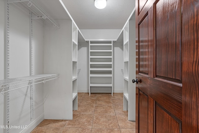 spacious closet featuring light tile patterned flooring