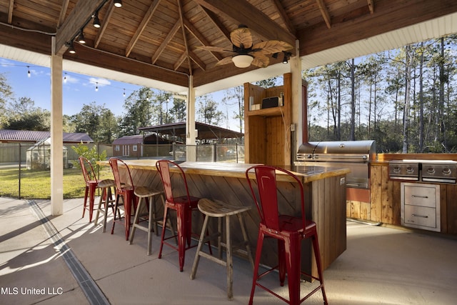 view of patio featuring a gazebo, area for grilling, ceiling fan, and an outdoor bar