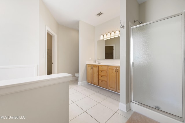 bathroom with vanity, toilet, tile patterned floors, and a shower with door