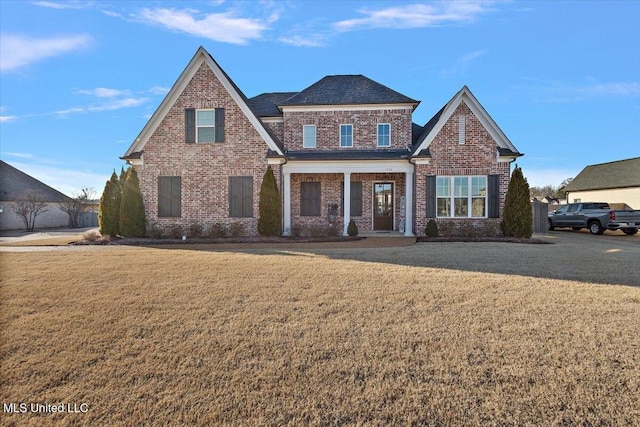 view of front facade featuring brick siding and a front lawn