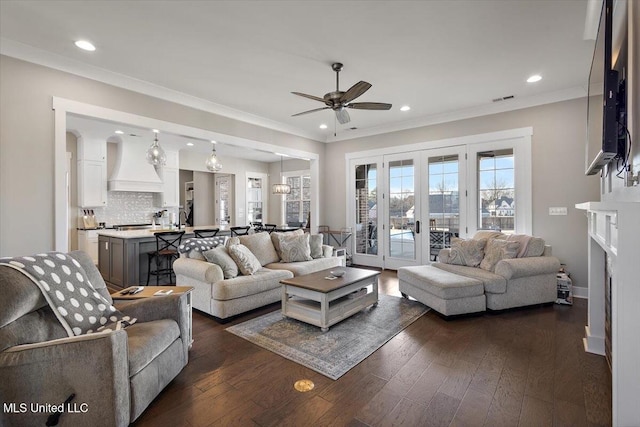 living area with dark wood-style floors, recessed lighting, ornamental molding, and french doors