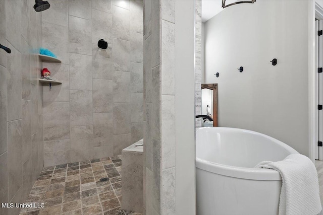 bathroom featuring walk in shower and a freestanding bath