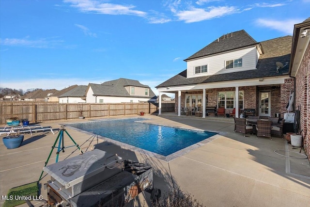 view of pool with a patio, french doors, a fenced backyard, and a fenced in pool