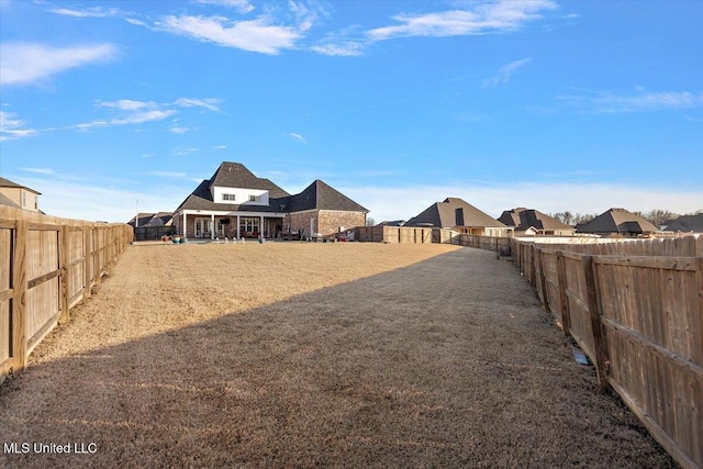 view of yard with a fenced backyard and a residential view