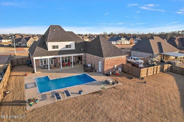 rear view of property with a patio, a fenced backyard, a residential view, and a fenced in pool