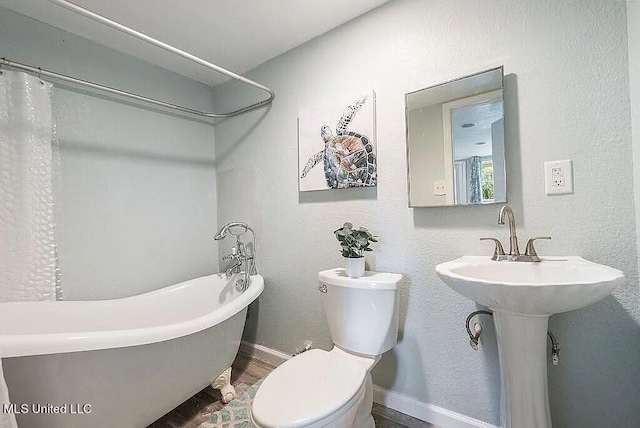 bathroom featuring hardwood / wood-style floors, toilet, and a bathing tub