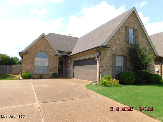 4283 Markston Dr, Southaven, MS 38672 - view of front of home with brick siding, concrete driveway, an attached garage, and roof with shingles
