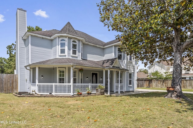 9000 Spring Ave, Ocean Springs, MS 39564 - victorian house featuring fence, a shingled roof, a front lawn, a chimney, and covered porch