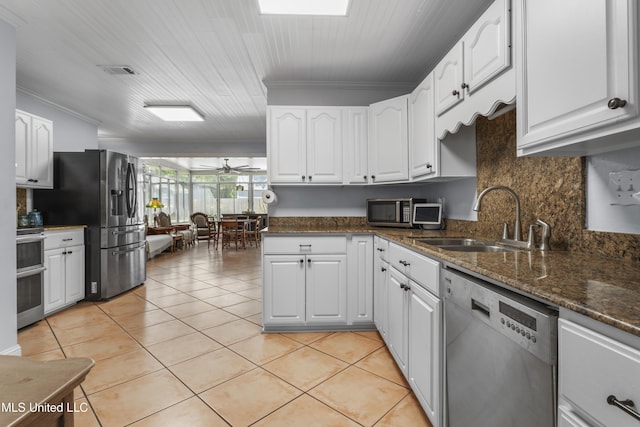 9000 Spring Ave, Ocean Springs, MS 39564 - kitchen with white cabinets, crown molding, a sink, stainless steel appliances, and light tile patterned floors