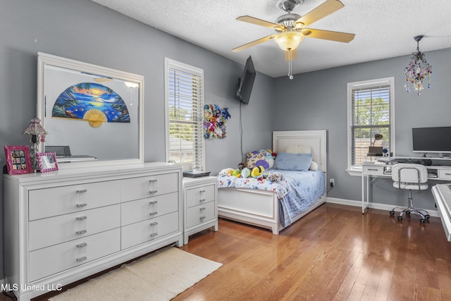 9000 Spring Ave, Ocean Springs, MS 39564 - bedroom featuring ceiling fan, a textured ceiling, baseboards, and wood finished floors
