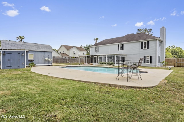 9000 Spring Ave, Ocean Springs, MS 39564 - view of swimming pool with a sunroom, a fenced backyard, an outbuilding, a patio area, and a lawn