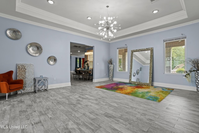 entrance foyer with a tray ceiling, wood finished floors, crown molding, and recessed lighting