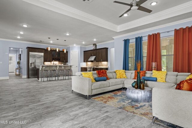 living area featuring crown molding, ceiling fan, recessed lighting, light wood-type flooring, and baseboards