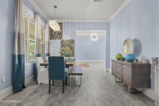 dining space featuring ornamental molding, wood finished floors, baseboards, and a chandelier