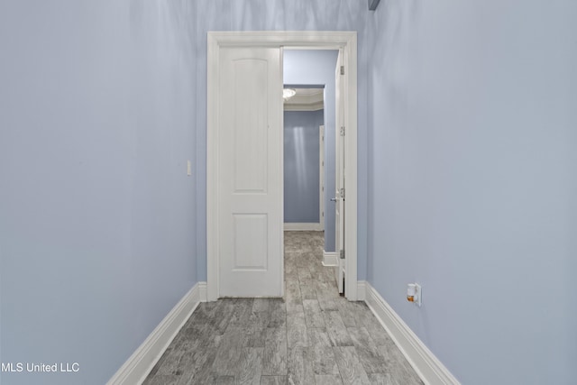 hallway with baseboards and wood finished floors
