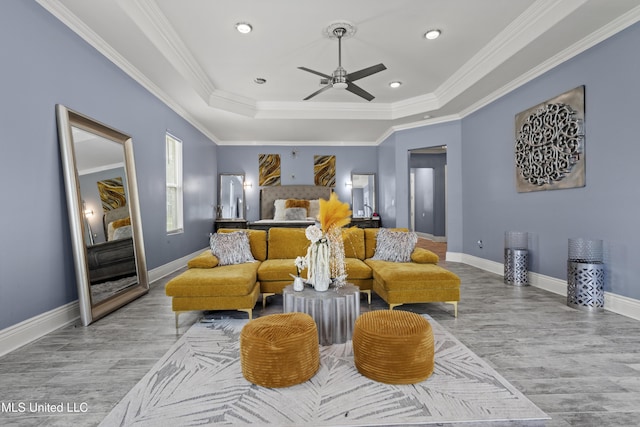 bedroom with a raised ceiling, wood finished floors, ornamental molding, baseboards, and recessed lighting