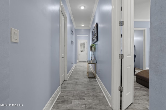 hallway featuring crown molding and baseboards