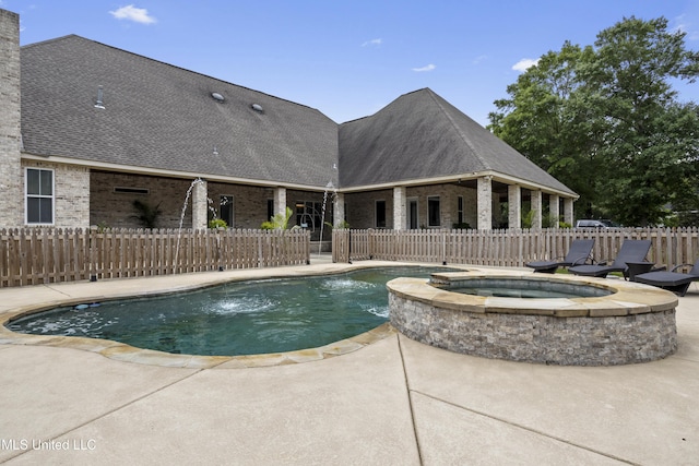 view of swimming pool with fence, a patio area, and a pool with connected hot tub