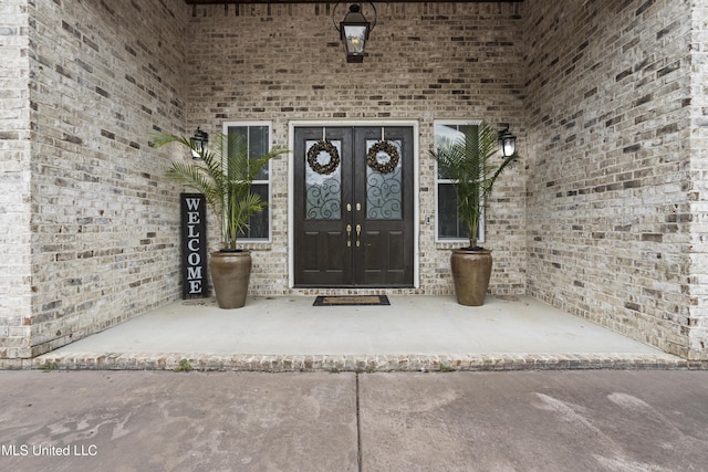 doorway to property featuring french doors and brick siding