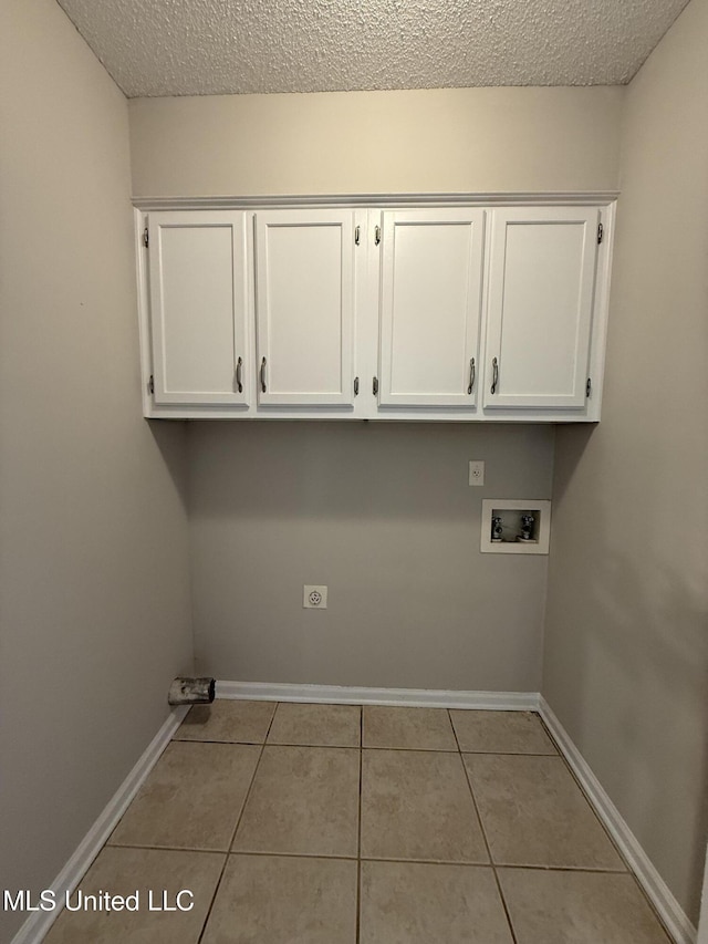 7120 Oak Forest Dr, Olive Branch, MS 38654 - laundry area featuring hookup for a washing machine, cabinet space, tile patterned floors, a textured ceiling, and electric dryer hookup