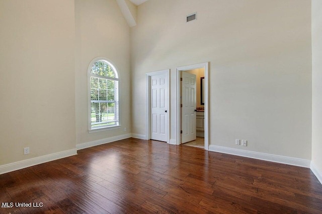 unfurnished room with high vaulted ceiling and dark hardwood / wood-style floors