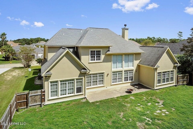 back of house featuring a patio area and a lawn