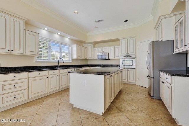 kitchen featuring appliances with stainless steel finishes, crown molding, a center island, and light tile patterned flooring