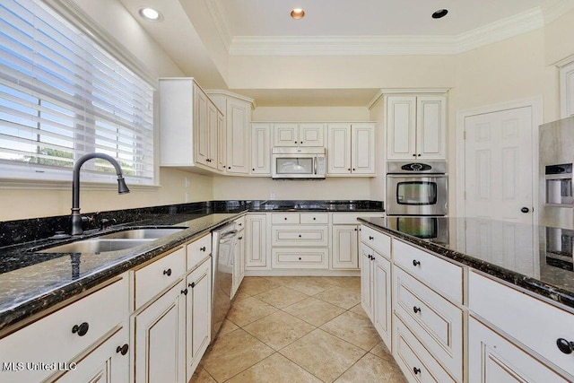 kitchen featuring appliances with stainless steel finishes, dark stone countertops, white cabinets, and sink