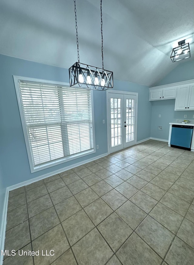 unfurnished dining area with lofted ceiling, light tile patterned floors, and french doors