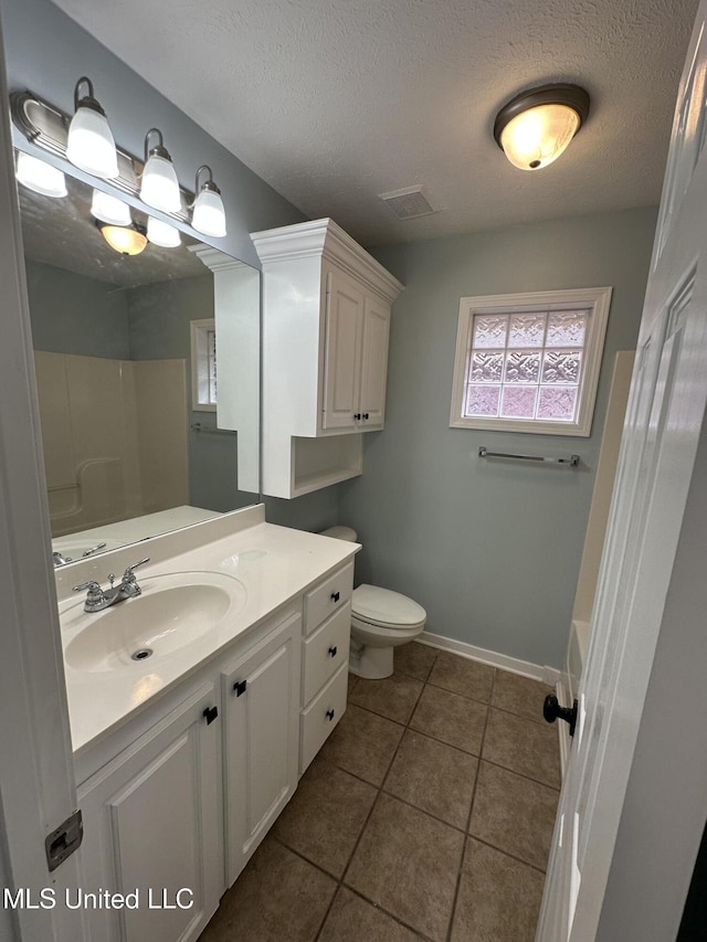 full bathroom with bathtub / shower combination, vanity, toilet, tile patterned floors, and a textured ceiling