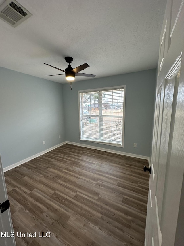 unfurnished room with dark hardwood / wood-style flooring, ceiling fan, and a textured ceiling