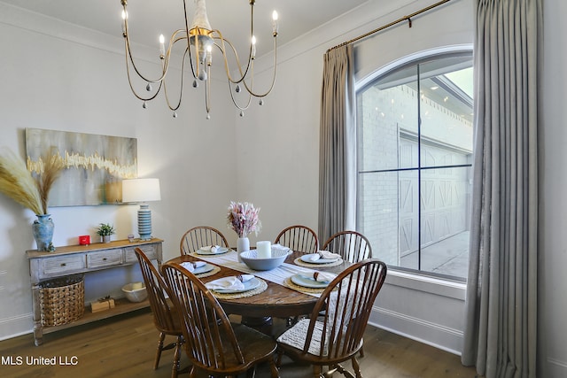 dining area featuring crown molding, dark hardwood / wood-style floors, and an inviting chandelier