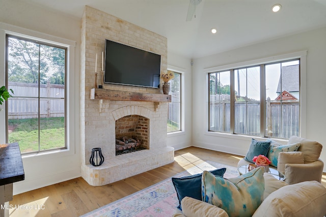 living room with a fireplace and light wood-type flooring