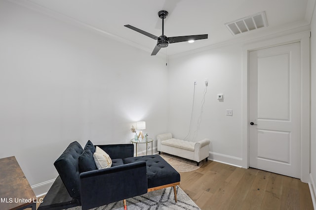 living room featuring crown molding, hardwood / wood-style floors, and ceiling fan