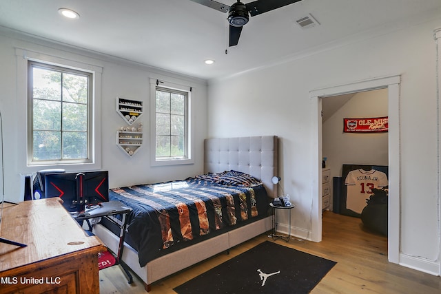 bedroom with ceiling fan, ornamental molding, and light wood-type flooring