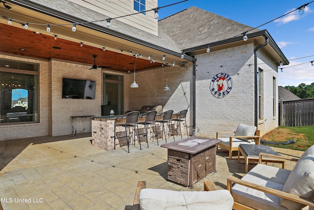 view of patio with an outdoor living space with a fire pit, ceiling fan, and exterior bar