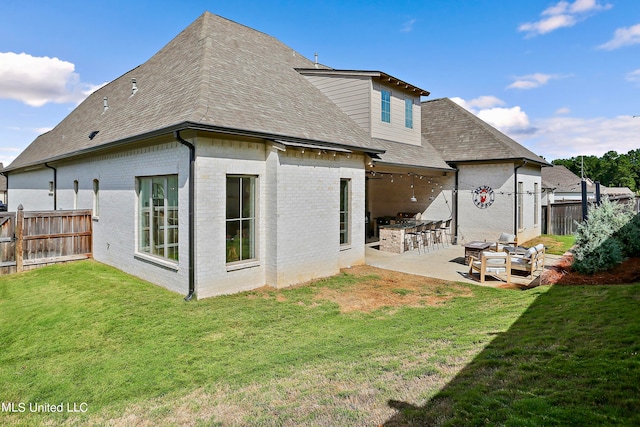 rear view of house featuring a lawn, an outdoor bar, and a patio area