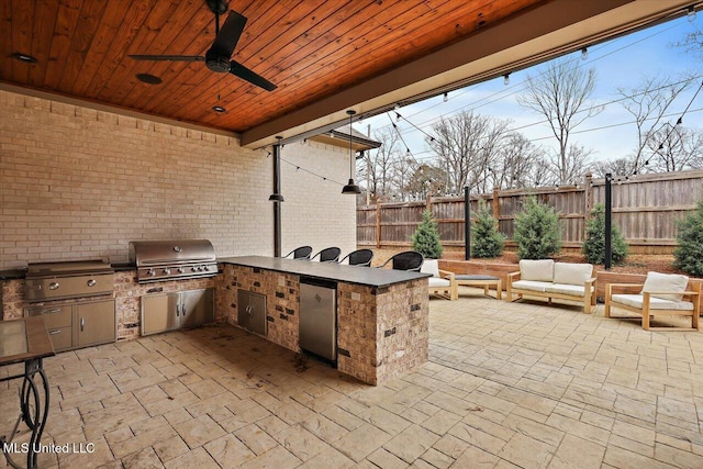 view of patio / terrace featuring ceiling fan, grilling area, an outdoor living space, and exterior kitchen