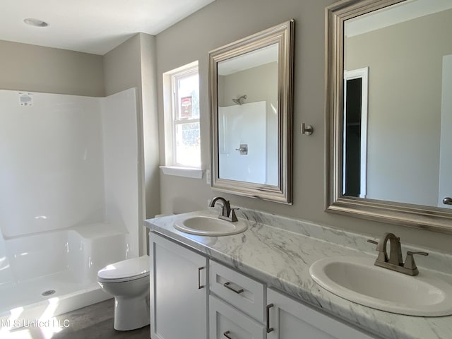 bathroom with vanity, toilet, a shower, and hardwood / wood-style floors