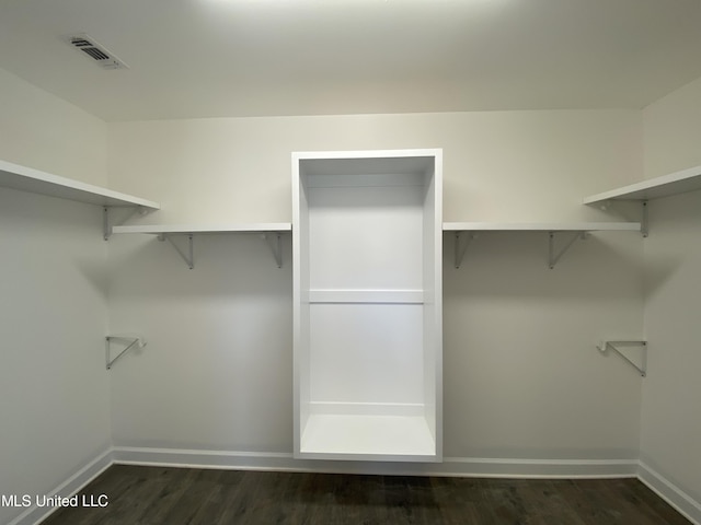 walk in closet with dark hardwood / wood-style floors