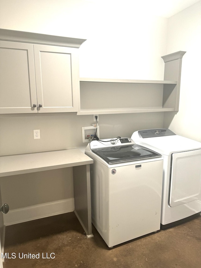 washroom with washer and dryer and cabinets