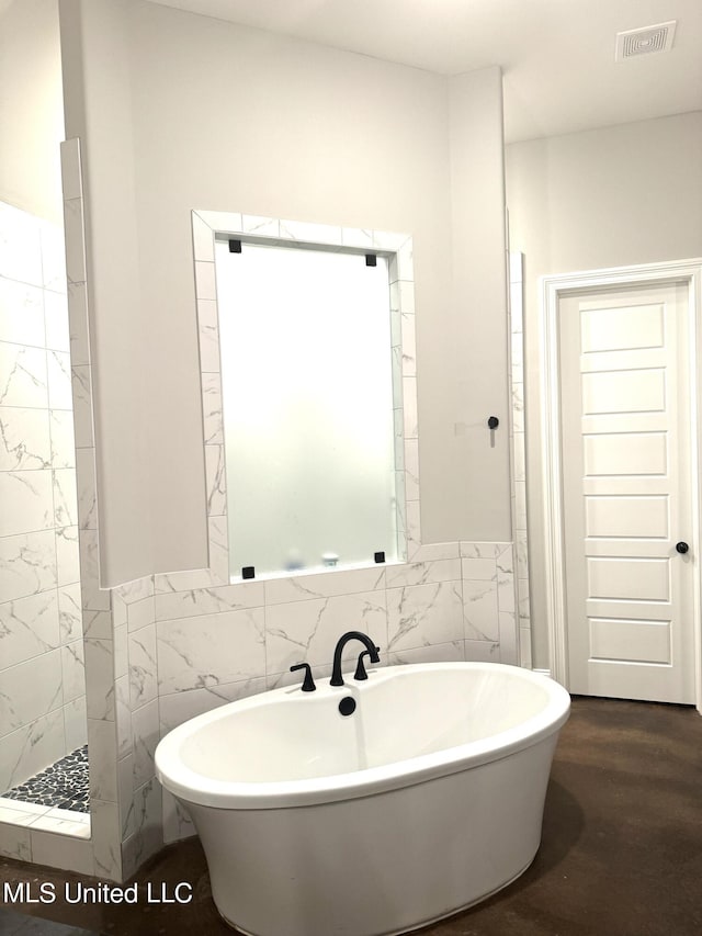 bathroom featuring tile walls, hardwood / wood-style floors, and plus walk in shower