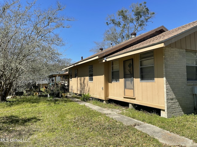 view of property exterior featuring a yard and roof with shingles