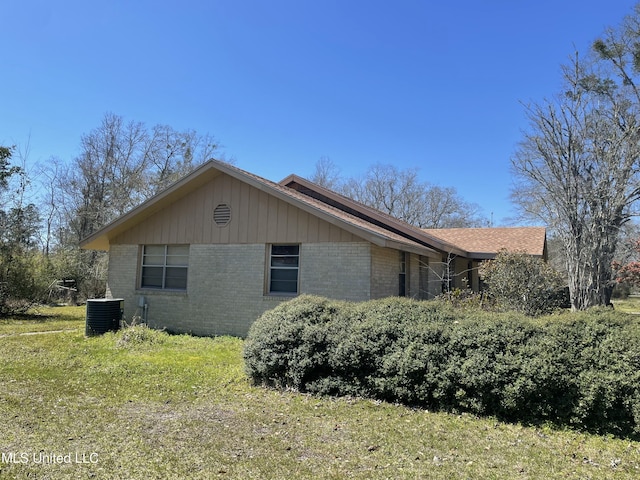 view of side of property with brick siding and central AC unit