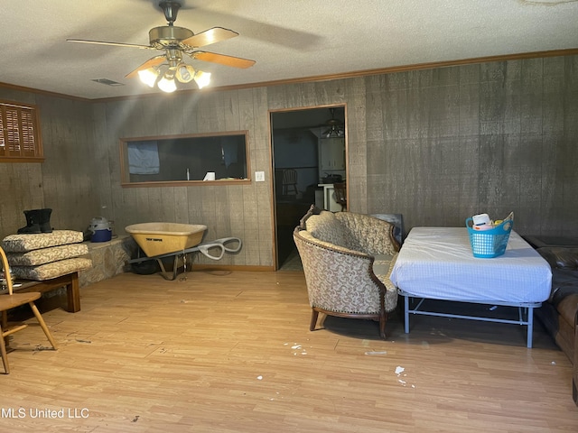 dining space featuring ceiling fan, a textured ceiling, wood finished floors, and ornamental molding