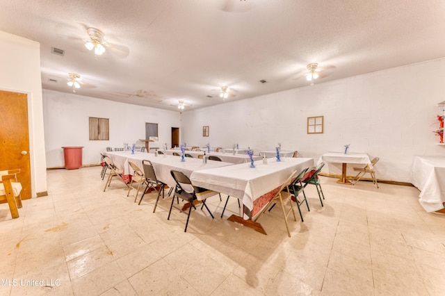 dining area with ceiling fan, light floors, baseboards, and visible vents