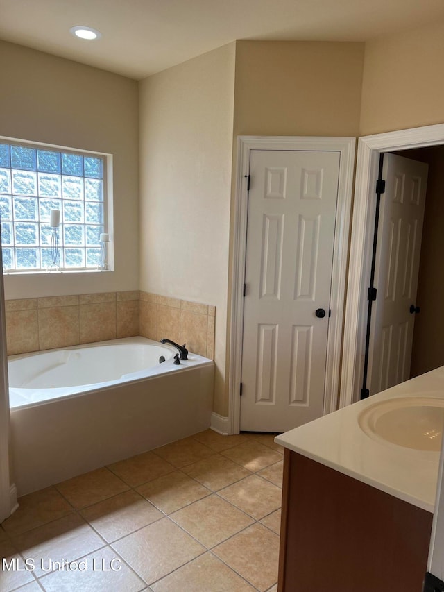 bathroom with vanity, a bath, and tile patterned flooring