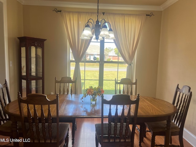 dining room featuring a notable chandelier, hardwood / wood-style flooring, and ornamental molding